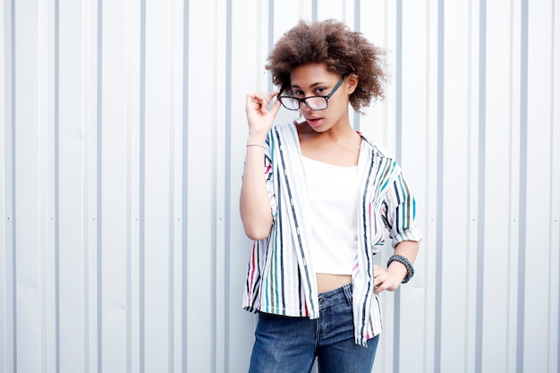 Drôle heureuse femme afro noire en t-shirt blanc et jeans