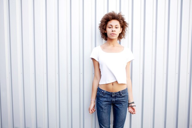 Drôle heureuse femme afro noire en t-shirt blanc et jeans