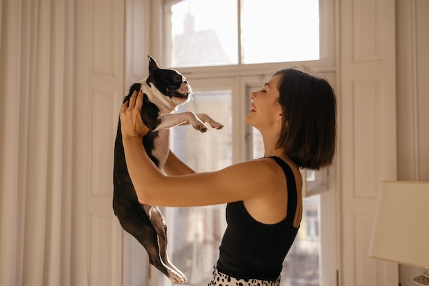 Drôle de jeune femme caucasienne propriétaire de chien passe la journée à la maison à jouer et à s'amuser ensemble Concept d'amour animal