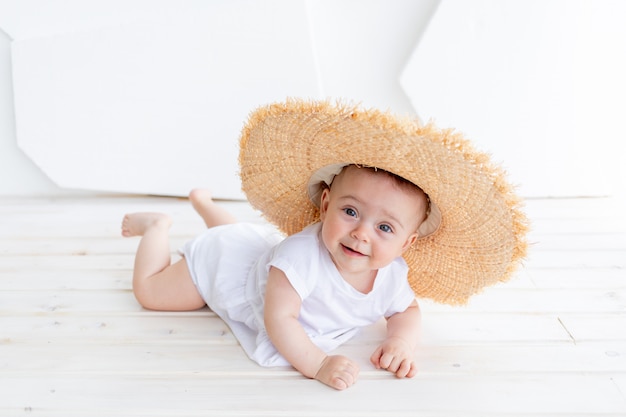 Drôle mignon enfant fille 3-4 ans tenant un chapeau de paille portant haut blanc et short en jean posant. Bonheur. L'été.