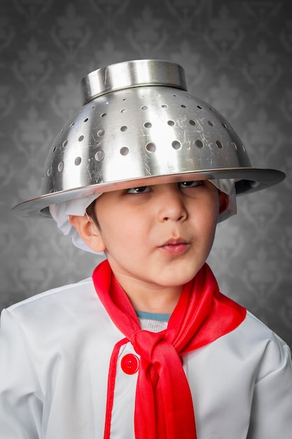 Photo un drôle de petit garçon cuisinier en uniforme sur fond vintage