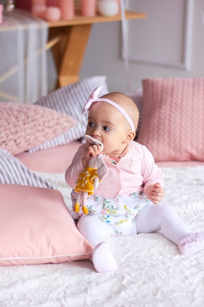 Drôle de petite fille dans un intérieur moderne et lumineux rose.