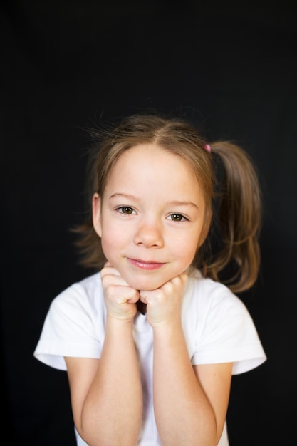 Drôle de petite fille sur fond sombre