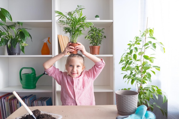 Drôle de petite fille qui s'occupe du concept de jardin à la maison de fleurs