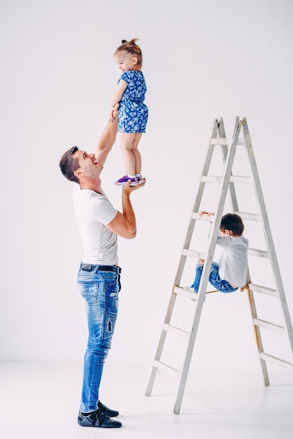 Drôle petite fille s'amuser dans la chambre des enfants blancs. Fille heureuse jouant avec son père.