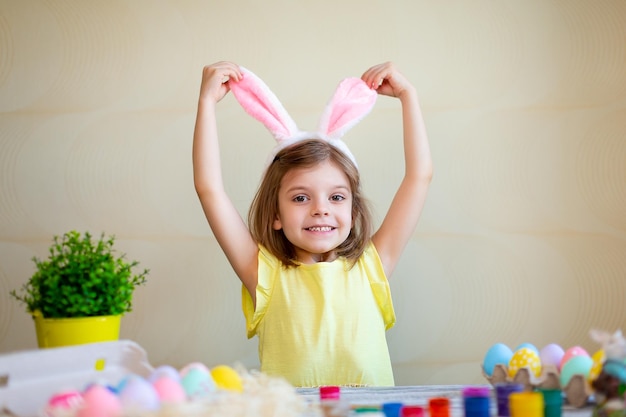 Drôle de préparation pour pâques oeufs peints de pâques enfant mignon fille porte des oreilles de lapins concept de pâques