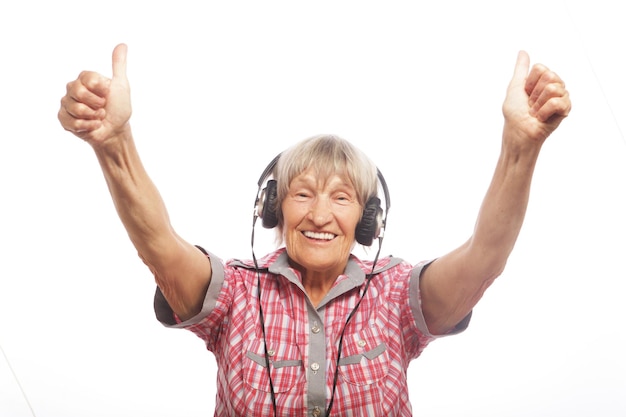 Drôle de vieille dame écoutant de la musique et montrant les pouces vers le haut