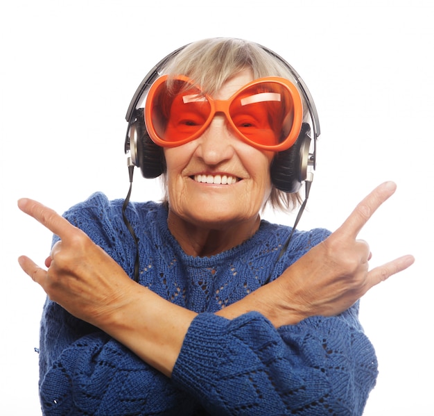 Photo drôle vieille dame écoutant de la musique et montrant les pouces vers le haut.