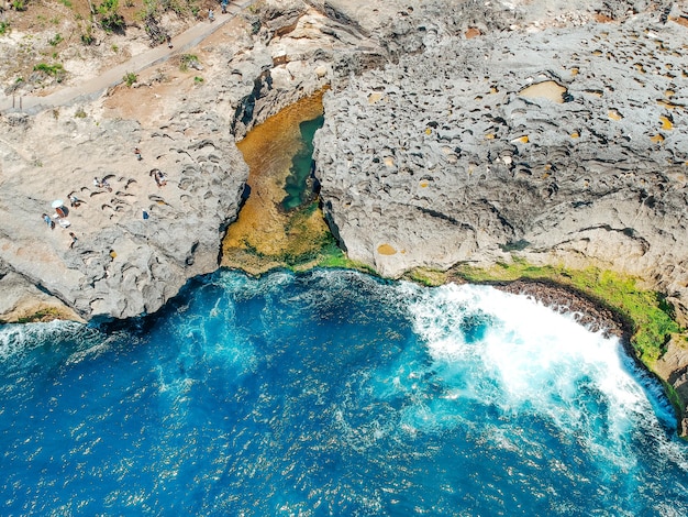 Drone aérien vue de dessus de la plage de corail et des vagues de l'océan bleu à Nusa Penida Bali Indonésie Vue aérienne de la côte rocheuse et des criques