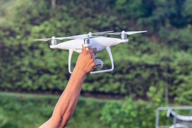 Drone blanc planant dans la matinée avec la main