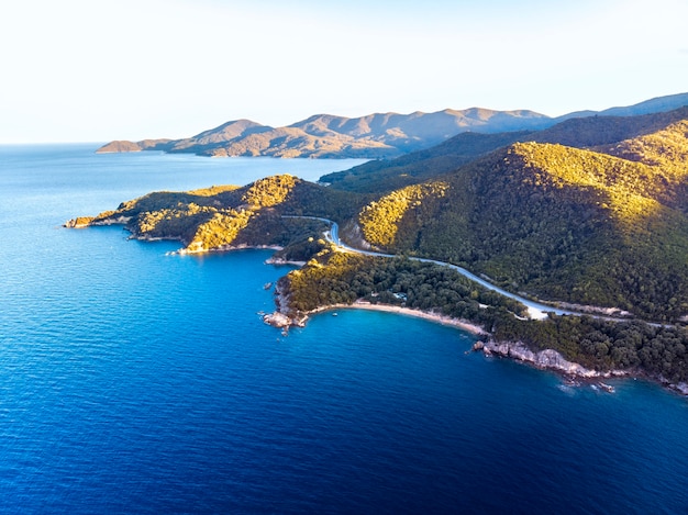 Drone panorama du coucher du soleil à Halkidiki avec mer bleue et montagnes, Grèce