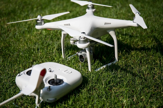 Drone en plastique blanc avec un gros plan du panneau de commande sur l'herbe