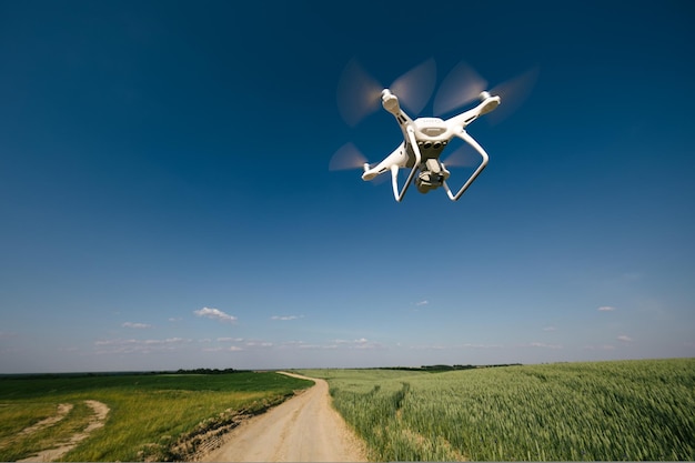 Drone quadcopter survolant le champ vert en été