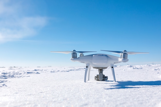 Drone volant au-dessus du champ couvert de neige aux beaux jours d'hiver