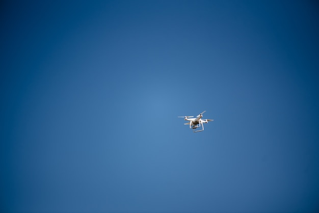 Drone volant de quad copter dans un ciel bleu clair