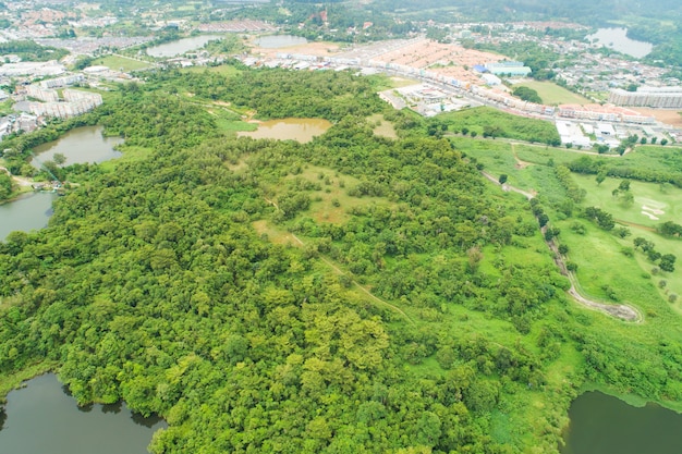 Drone de vue aérienne Tir de haut en bas d'une forêt abondante avec la ville qui entoure la forêt en été Vue grand angle Environnement naturel Concept.