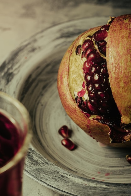 Photo du jus de grenade et de grenade sur la table fond sombre