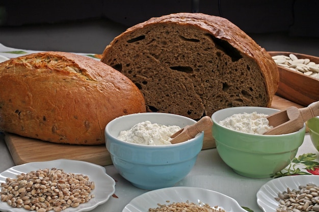 Du pain avec de la farine et du blé sur la table de la cuisine.