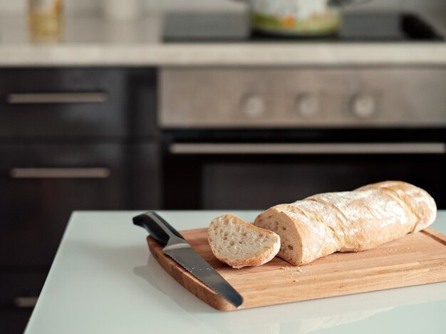 Du pain fraîchement cuit se trouve sur la planche à découper dans la cuisine