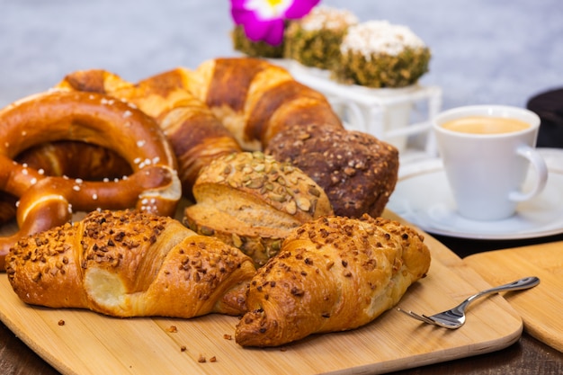 Du pain frais parfumé avec du café et une belle fleur est un bon petit déjeuner pour le corps sur la table.