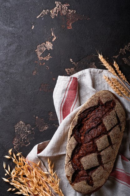 Du pain maison fraîchement cuit sur du seigle au levain artisanal sur fond de pierre de taille ou de béton. Vue de dessus. Fond de cuisson des aliments. Espace de copie.