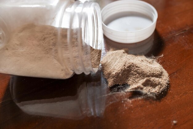 Photo du poivre moulu dans un pot sortant sur une table en bois brune photo concept photo stock photo