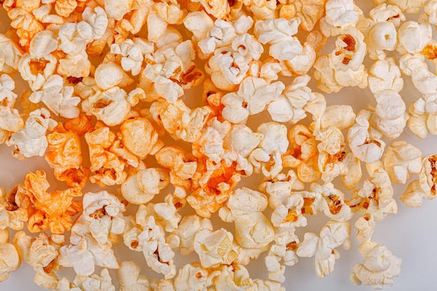 du pop-corn éparpillé sur un fond blanc en gros plan