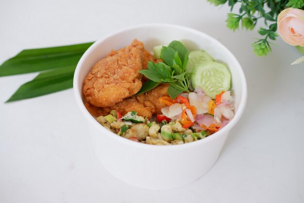 du riz avec du poulet et des légumes dans une tasse