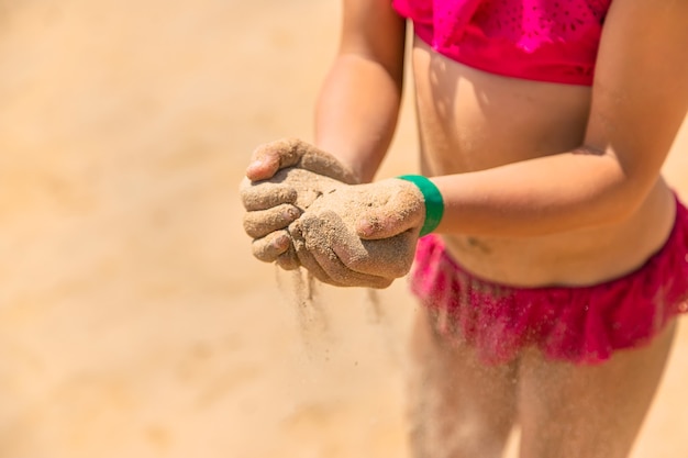 Du sable entre les mains d'un enfant