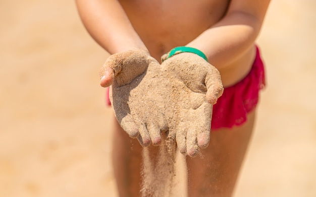 Du sable entre les mains d'un enfant