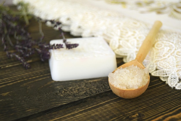 Photo du sel et du savon fait maison avec des herbes sur fond de bois