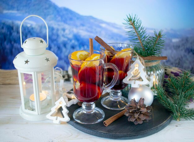 Du vin moulu avec des épices et des décorations de Noël sur une table en bois