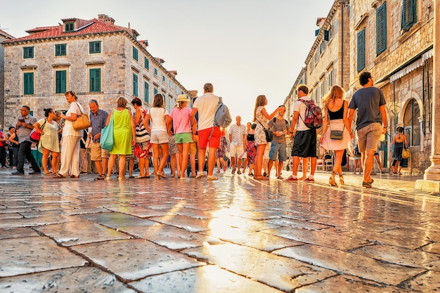 Dubrovnik, Croatie - 20 août 2016 : Des foules de touristes dans la rue Stradun au coucher du soleil dans la vieille ville de Dubrovnik, Croatie. Soleil reflété dans la pierre.