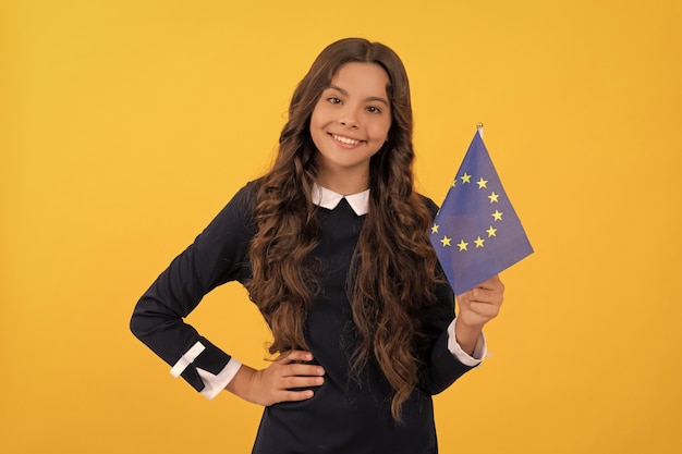 Éducation à l'école de langue étrangère enfant joyeux tenant le drapeau de l'union européenne