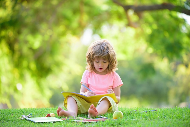 Éducation des enfants en plein air. Enfant de l'école primaire étudiant dans le parc.