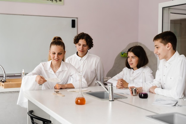 Éducation Expériences chimiques lors d'une leçon de chimie à l'école Les camarades de classe des enfants tiennent des tubes à essai et mènent des expériences en laboratoire