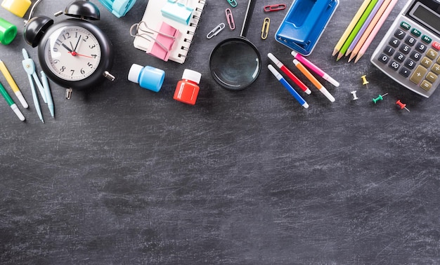 Éducation ou retour à l'école Concept Vue de dessus des fournitures scolaires colorées avec des livres crayons de couleur calculatrice coupe-stylo et clips sur fond de panneau