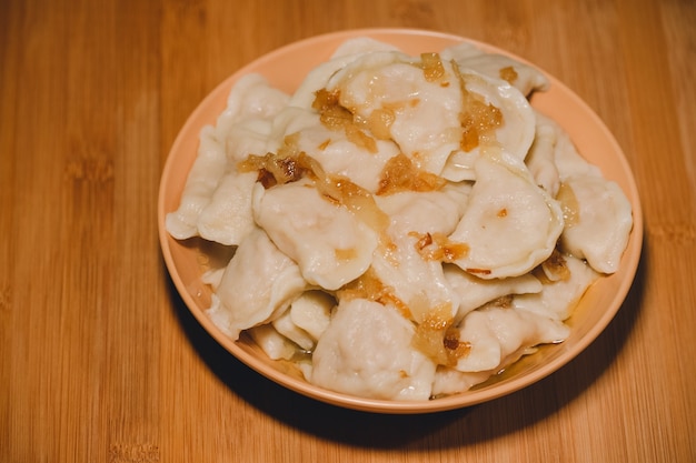 Dumplings dans un bol avec des oignons frits. Dumplings, farcis de purée de pommes de terre servis avec oignon frit