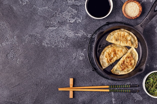 Photo dumplings frits avec sauce soja et baguettes