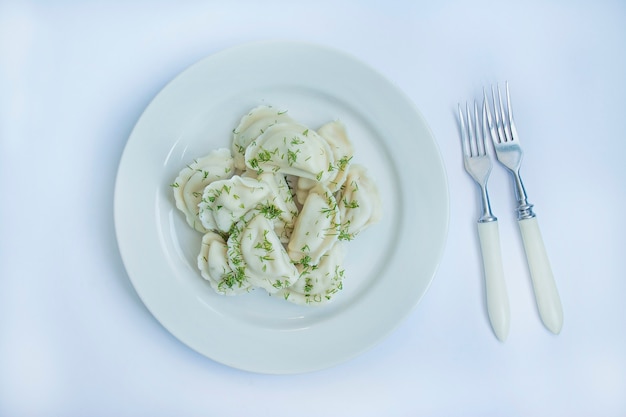 Dumplings avec des pommes de terre sur une assiette blanche. Blanc . Plat traditionnel de l'Ukraine.