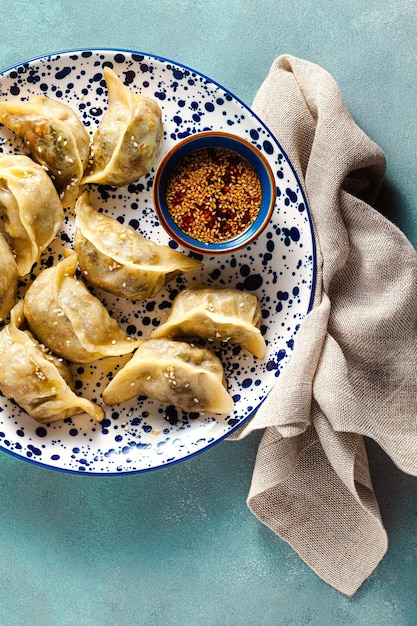 Dumplings Wonton avec sauce au sésame épicée sur la table.