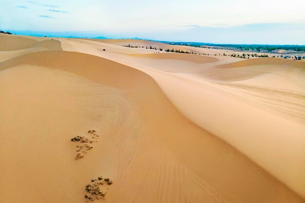 Dunes de sable près de Mui Ne. Groupe de hors-pistes au sommet des dunes en arrière-plan. Journée ensoleillée avec ciel bleu