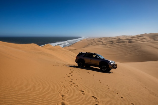 Photo dunes de sable se déplaçant sur la côte atlantique jeep tour dans le parc national de naukluft en namibie