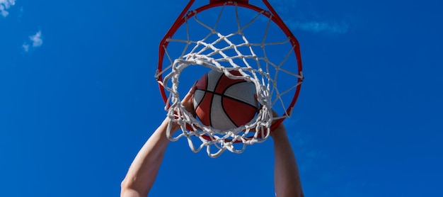 Dunk in basket slam dunk in motion activité estivale homme souriant avec ballon de basket Conception d'affiches horizontales Bannière Web en-tête copie espace