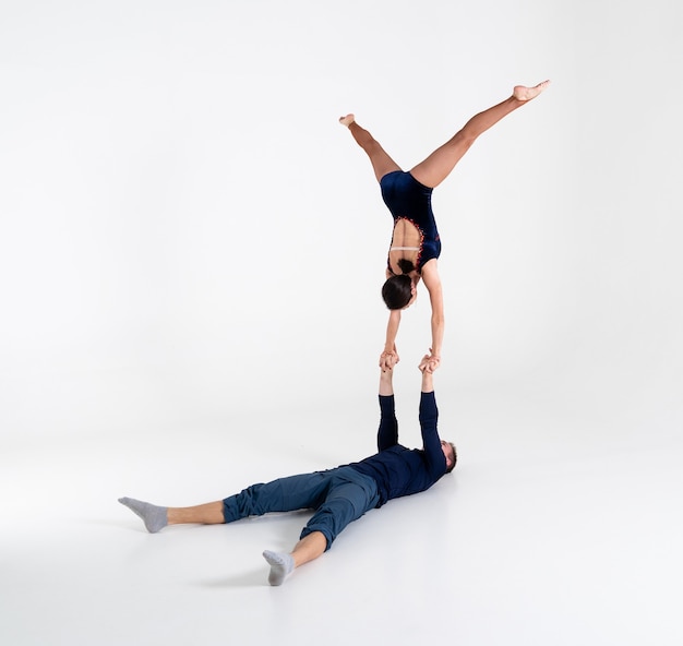 Duo d'acrobates mâles et femelles montrant le tour de main à main, isolé sur blanc