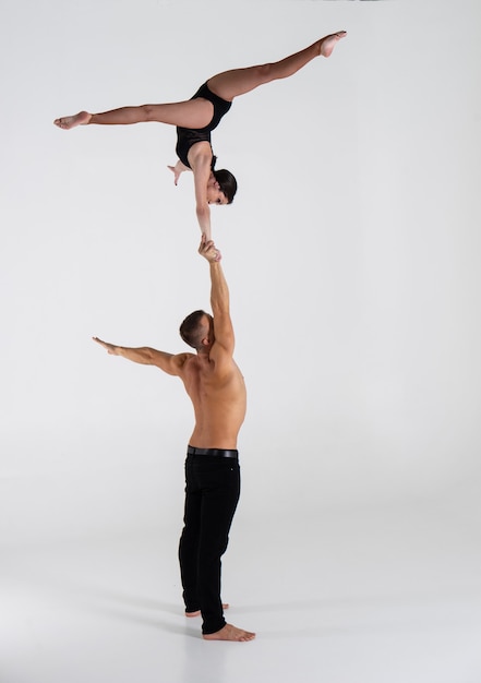 Duo d'acrobates mâles et femelles montrant un tour de main à main