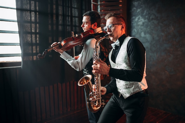 Duo homme saxophone et violoniste jouant la mélodie classique