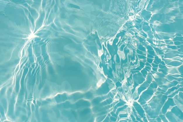 Une eau bleue dans une piscine avec le soleil qui brille dessus.