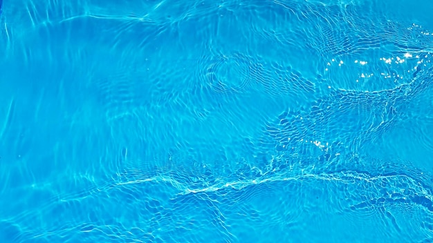 Eau bleue avec des ondulations sur la surface Défocalisation floue eau calme claire de couleur bleue transparente