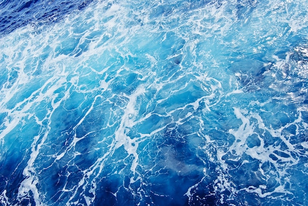 L'eau bleue ondule sur le fond des vagues de l'océan.